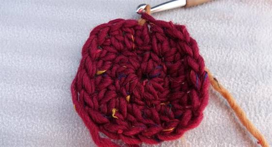 Die 2. Runde des gehäkelten Sitzkissens aus Filzwolle wird mit einer Kettmasche beendet.